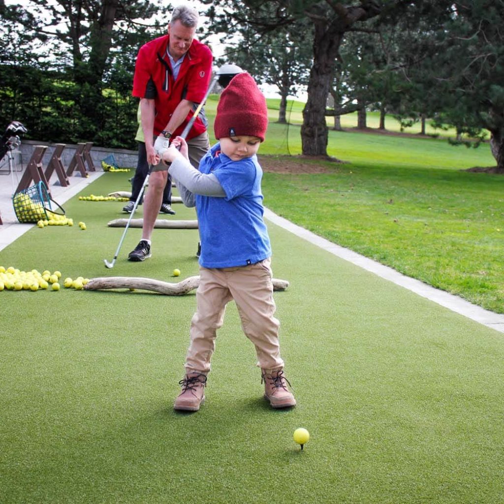 Kid teeing off on SYNLawn artificial grass in Little Rock, AR