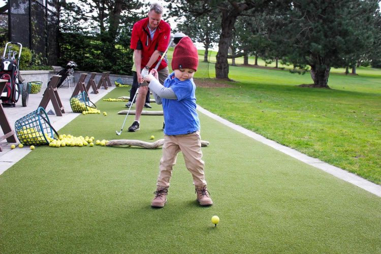 Kid teeing off on SYNLawn artificial grass in Little Rock, AR